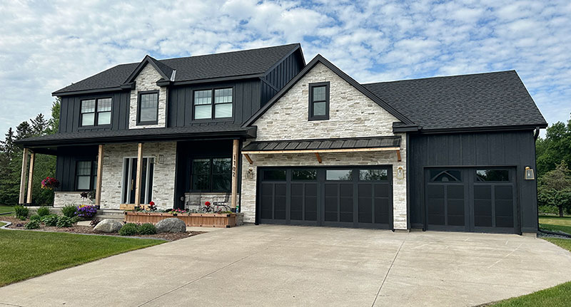 After photo of Sartell home where stone was added, new black siding and new black roofing