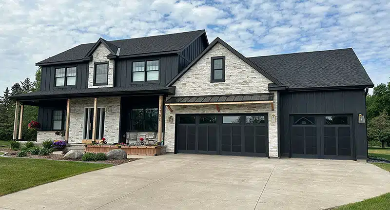 After photo of Sartell home where stone was added, new black siding and new black roofing