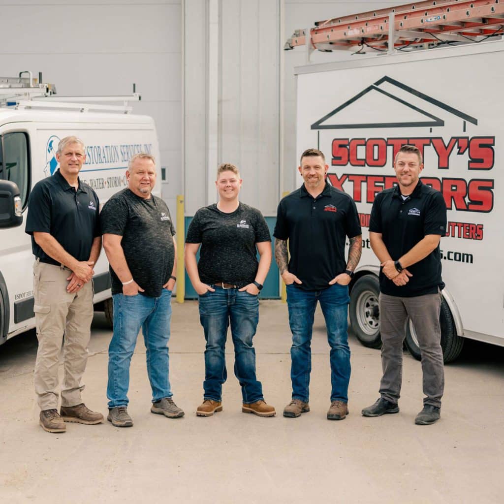Scotty's Exteriors Team and SB Restoration Team Leaders together in front of service vehicles